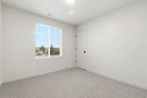Carpeted empty room featuring baseboards