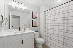 Bathroom with a shower with shower curtain, vanity, and light wood-style floors