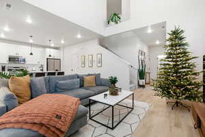 Living room featuring stairs, light wood-style flooring, and recessed lighting