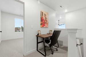 Home office with light carpet and a textured ceiling