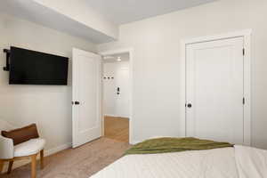 Bedroom featuring light carpet and baseboards