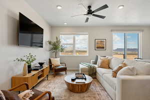 Living room featuring a ceiling fan, a textured ceiling, and recessed lighting