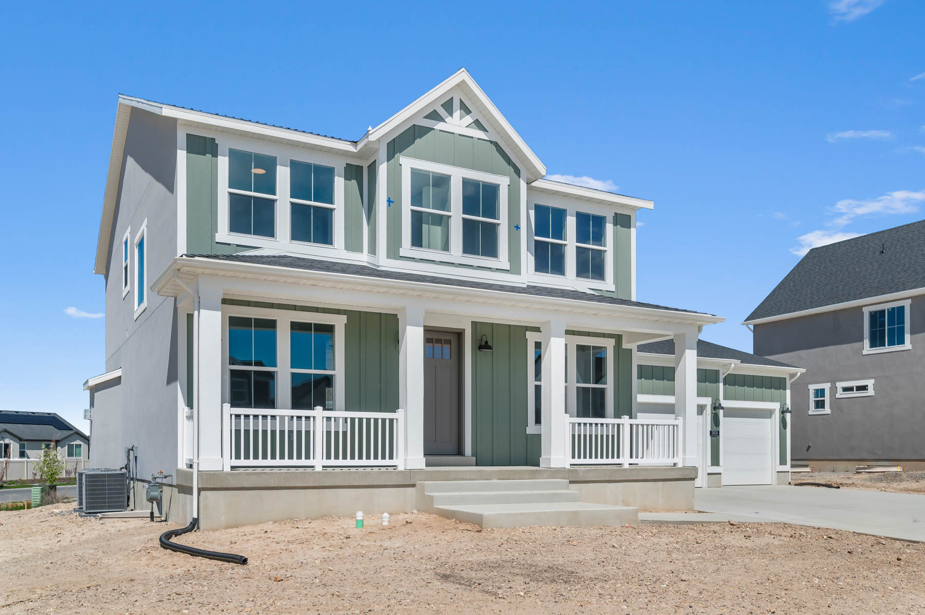 View of front facade with board and batten siding, a porch, concrete driveway, and a garage