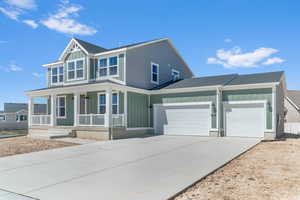 View of front of home with board and batten siding, a garage, roof with shingles, and concrete driveway