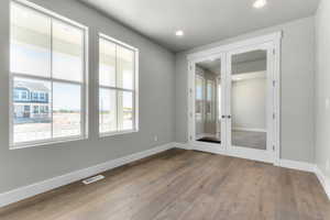 Unfurnished room with light wood-style flooring, french doors, and recessed lighting