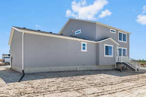 Back of property featuring stucco siding