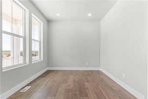 Empty room with light wood-type flooring and recessed lighting