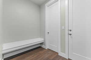 Mudroom featuring dark wood-type flooring and baseboards