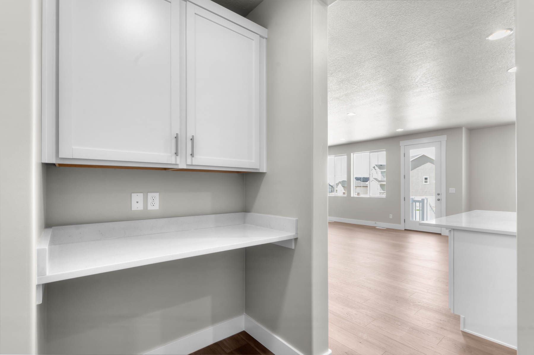 Detailed view of wood finished floors, a textured ceiling, and recessed lighting