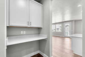 Detailed view of wood finished floors, a textured ceiling, and recessed lighting