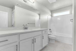 Bathroom featuring vanity, bathing tub / shower combination, light marble finish floors, and a textured ceiling