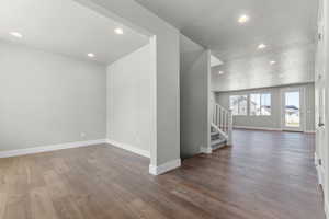 Spare room featuring recessed lighting and dark wood-style flooring