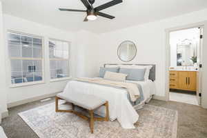 Bedroom featuring light colored carpet, connected bathroom, and a ceiling fan