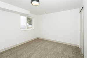 Spare room featuring carpet flooring and baseboards