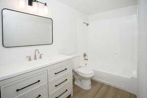 Bathroom featuring vanity, shower / bath combination, and light wood-type flooring