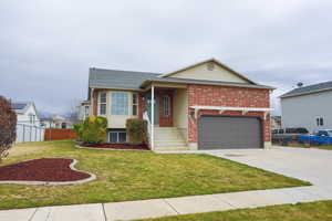 View of front of home with driveway and brick siding