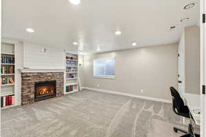 Unfurnished office featuring a fireplace, light colored carpet, and recessed lighting