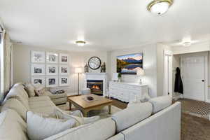 Living area featuring a glass covered fireplace and carpet