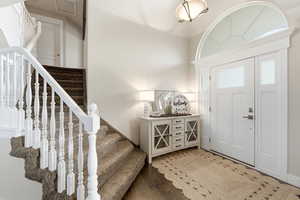 Entryway with wood finished floors and stairway