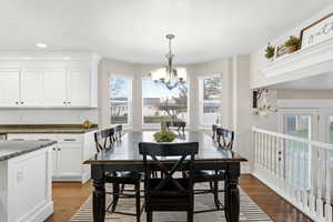 Dining area featuring dark wood-style flooring and a chandelier