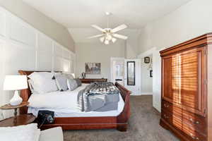 Bedroom with vaulted ceiling, carpet flooring, and ceiling fan