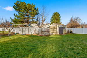 Fenced backyard featuring a storage shed