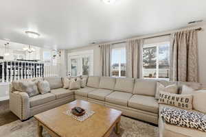 Carpeted living room featuring plenty of natural light and a chandelier
