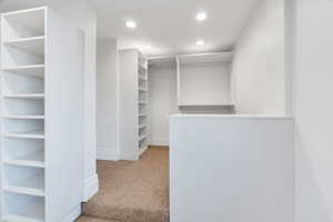 Walk in closet featuring light carpet