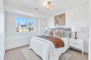 Bedroom featuring light carpet