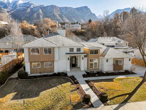 View of front of property with a shingled roof, a mountain view, a chimney, and a residential view