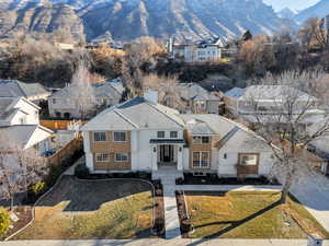 View of front facade featuring a residential view, a mountain view, a shingled roof, and a chimney