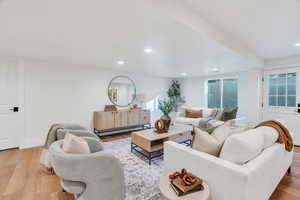Living room featuring wood finished floors, a baseboard radiator, and recessed lighting