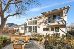 Back of property with stucco siding, a patio, and an outdoor fire pit