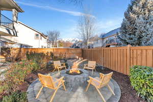 Fenced backyard featuring a patio area, a residential view, and a fire pit