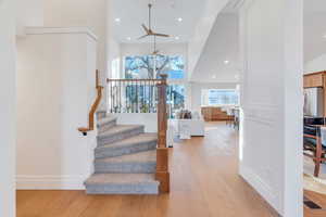 Stairway with wood finished floors, healthy amount of natural light, recessed lighting, and a ceiling fan