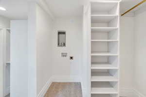 Laundry area with light colored carpet, hookup for a washing machine, and hookup for an electric dryer