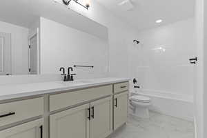 Full bathroom featuring vanity, light marble finish flooring, washtub / shower combination, and recessed lighting