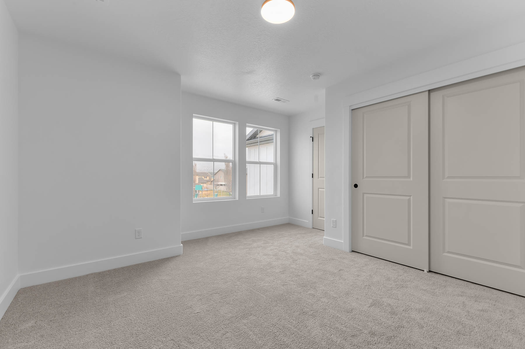 Unfurnished bedroom featuring light carpet and a closet