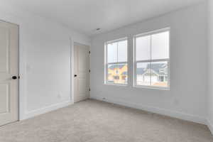 Unfurnished bedroom with baseboards and light colored carpet