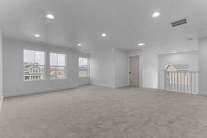 Spare room featuring light colored carpet and recessed lighting