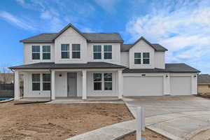 Modern farmhouse with concrete driveway, a porch, board and batten siding, and a shingled roof