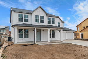 Modern farmhouse with board and batten siding, driveway, covered porch, a shingled roof, and a garage