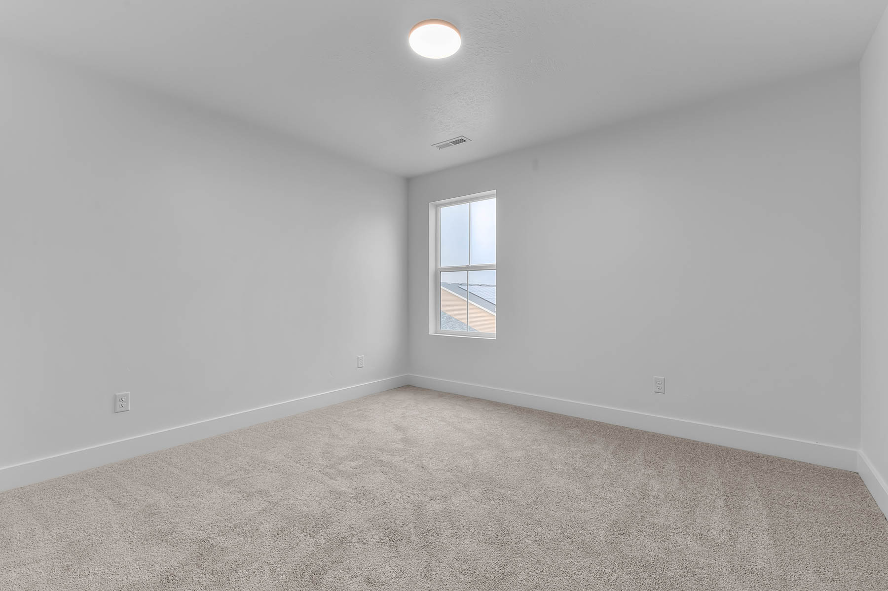 Empty room featuring baseboards and light colored carpet