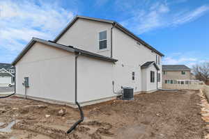 View of side of home with stucco siding and a cooling unit
