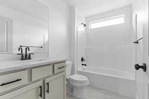 Bathroom featuring vanity, bathtub / shower combination, and light marble finish floors