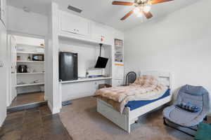 Bedroom featuring stone tile floors and ceiling fan
