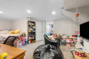 Bedroom with light colored carpet, ornamental molding, and recessed lighting