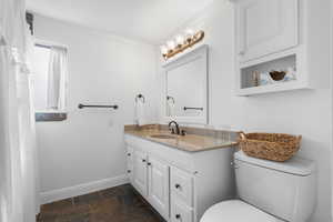 Bathroom with vanity, stone finish floors, crown molding, and a shower with curtain
