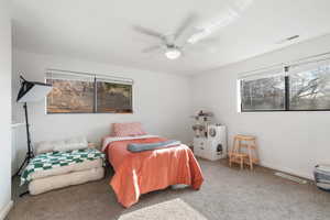Carpeted bedroom featuring ceiling fan and baseboards