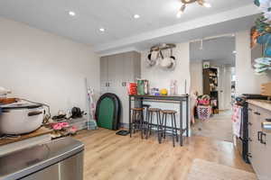Kitchen featuring gas stove, light countertops, light wood finished floors, and recessed lighting
